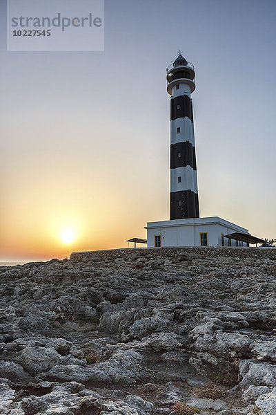 Spanien  Balearen  Menorca  Blick auf Artrutx Leuchtturm bei Sonnenuntergang