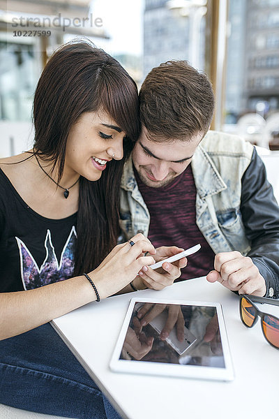 Spanien  Gijon  junges Paar beim Betrachten von Bildern auf dem Smartphone