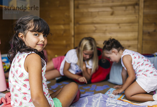 Spanien  Asturien  Gijon  Kleine Mädchen spielen in einem kleinen Holzhäuschen
