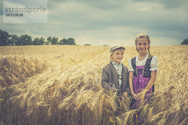 Deutschland  Sachsen  zwei Kinder auf einem Getreidefeld stehend