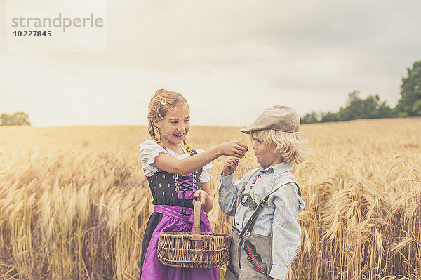 Deutschland  Sachsen  zwei Kinder stehen vor einem Getreidefeld