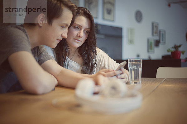Teenager-Paar mit Smartphone zu Hause