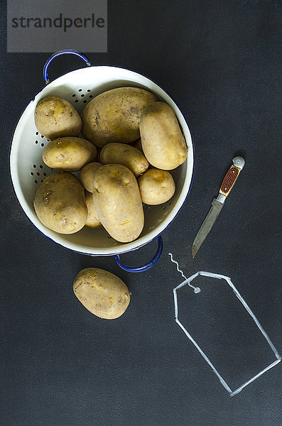 Sieb aus rohen Kartoffeln und einem Messer auf Schwarzwild mit gezogenem Etikett