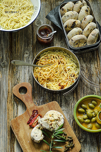 Spaghetti mit Tomatenpesto  Parmesan und selbstgemachten Brötchen aus Oliven und Tomaten auf Holzbrettchen