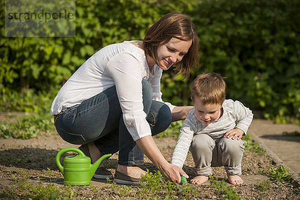Mutter und ihr kleiner Sohn bei der Gartenarbeit