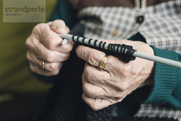 Hände der älteren Frau beim Stricken