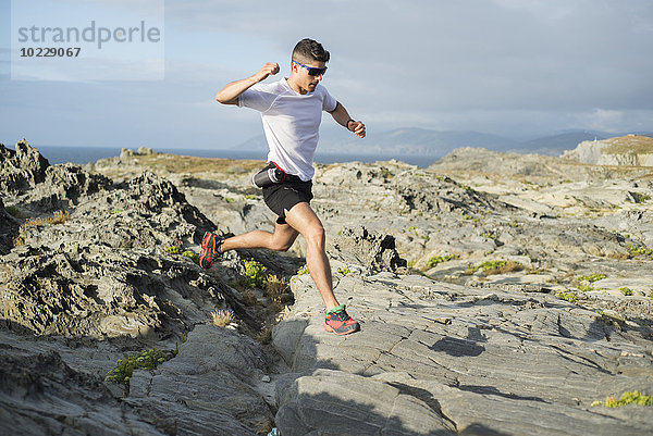 Spanien  Valdovino  junger Mann beim Trailrunning in einer felsigen Landschaft