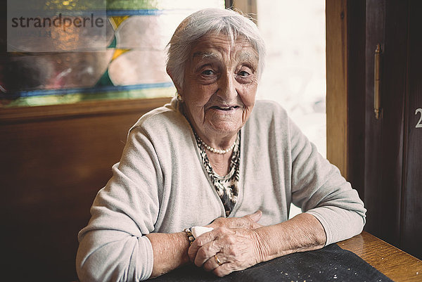 Porträt einer lächelnden Seniorin im Restaurant