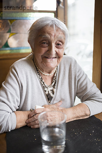 Porträt einer lächelnden Seniorin im Restaurant