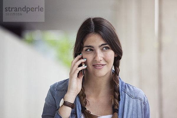 Junge Frau telefoniert mit Smartphone