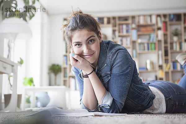Porträt einer lächelnden jungen Frau  die sich zu Hause entspannt