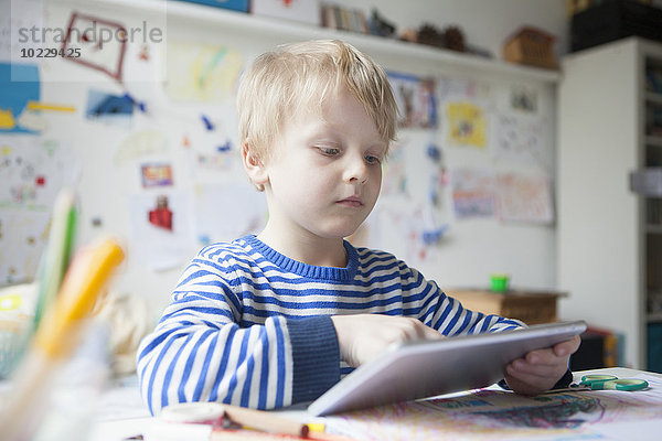 Porträt eines blonden kleinen Jungen mit digitalem Tablett