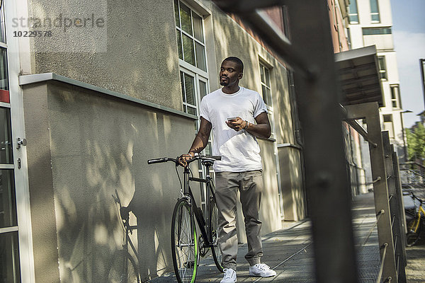 Portrait eines jungen Mannes mit Fahrrad
