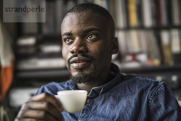 Porträt eines jungen Mannes mit einer Tasse Kaffee