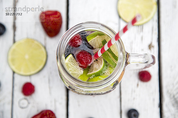 Fruchtlimonade mit Früchten und Mineralwasser im Glas  Trinkhalm