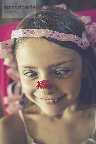 Portrait des kleinen Mädchens mit'Happy gluing Birthday' an der Nase