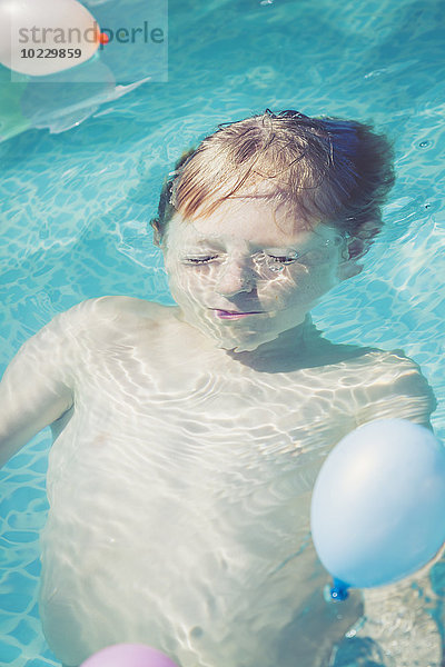 Junge im Schwimmbad Tauchen unter