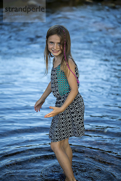 Porträt des lächelnden Mädchens im Wasser stehend