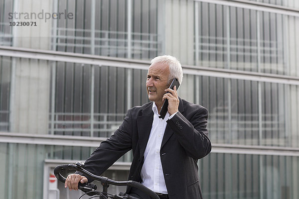 Geschäftsmann mit Fahrradtelefonie mit Smartphone
