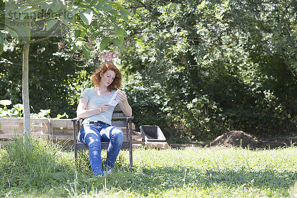 Junge Frau beim Lesen im Garten