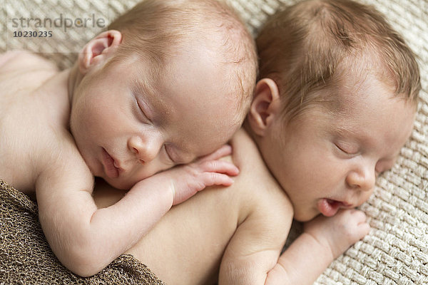 Porträt von neugeborenen Zwillingen  die auf einer Decke schlafen.
