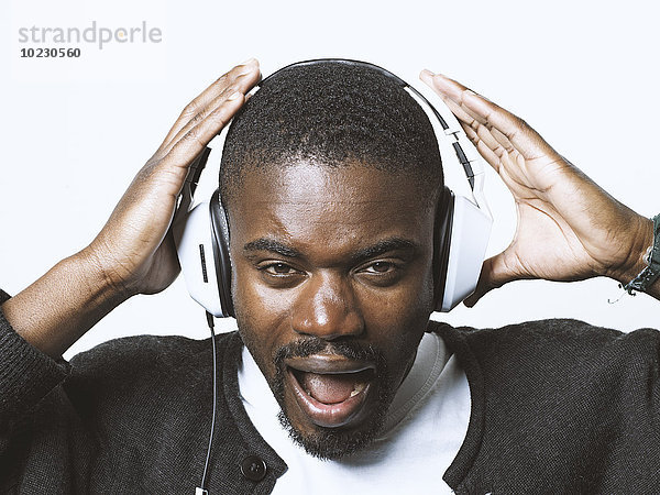 Portrait eines schreienden jungen Mannes mit Kopfhörer