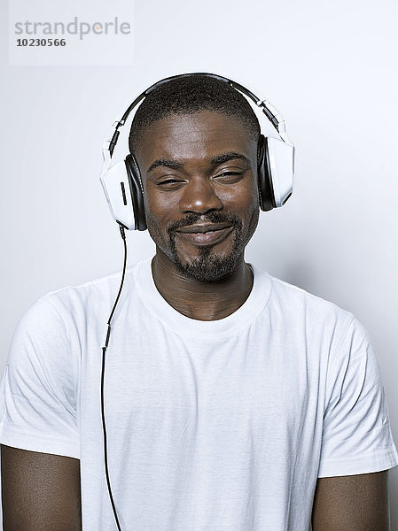 Porträt eines lächelnden jungen Mannes mit Kopfhörer