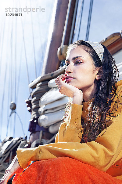 Nachdenkliche junge Frau entspannt auf einem Segelschiff
