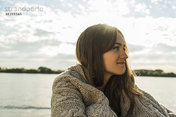 Lächelnde junge Frau am Flussufer