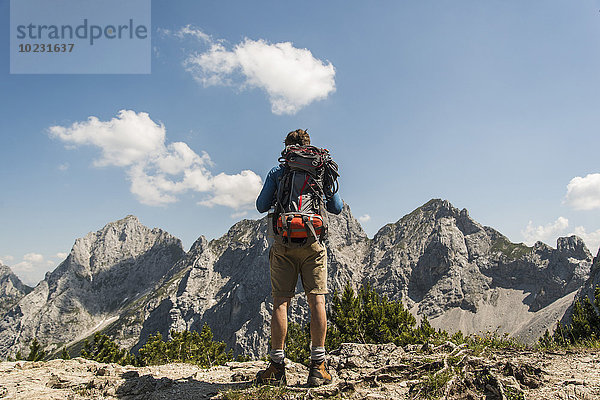 Österreich  Tirol  Tannheimer Tal  junger Mann auf dem Bergpfad mit Blick auf die Aussicht