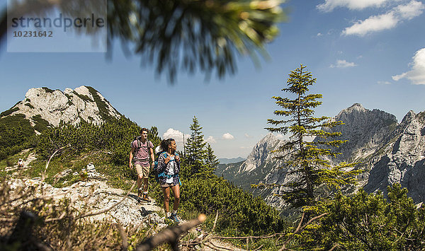 Österreich  Tirol  Tannheimer Tal  junges Paar Wandern auf dem Bergweg
