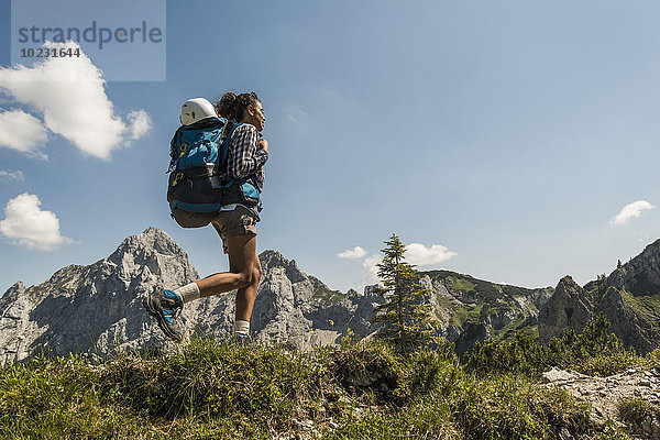 Österreich  Tirol  Tannheimer Tal  junge Frau beim Wandern auf dem Bergweg