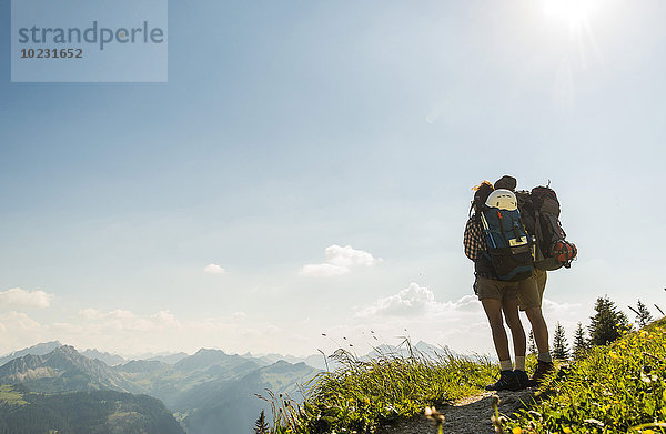 Österreich  Tirol  Tannheimer Tal  junges Paar auf dem Bergpfad stehend mit Blick auf die Aussicht