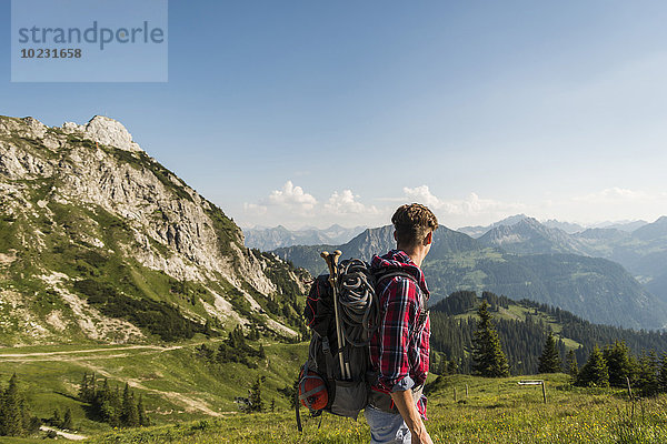 Österreich  Tirol  Tannheimer Tal  junger Mann beim Wandern auf Almen