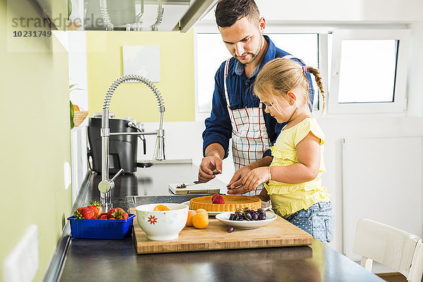 Vater und Tochter in der Küche bei der Zubereitung von Obstkuchen