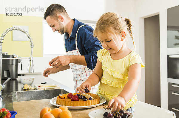 Vater und Tochter in der Küche bei der Zubereitung von Obstkuchen