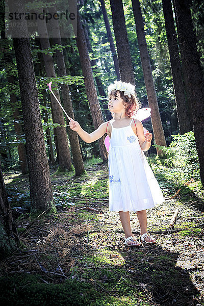 Kleines Mädchen verkleidet als Fee im Wald