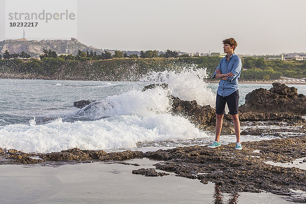 Griechenland  Rhodos  junger Mann an der Strandpromenade mit Blick auf die Ferne