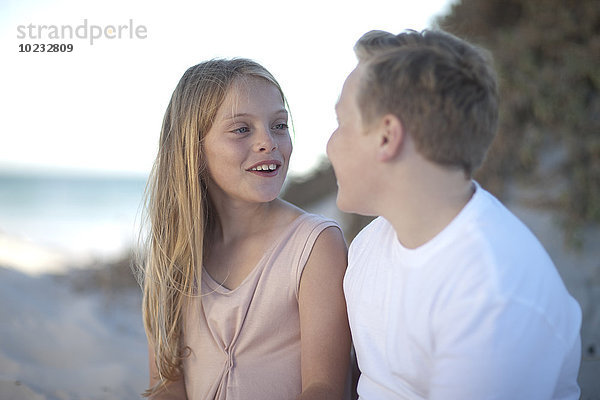 Lächelnder Teenager Junge und Mädchen am Strand
