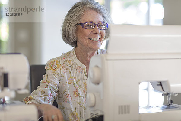 Seniorin bei der Arbeit an der Nähmaschine