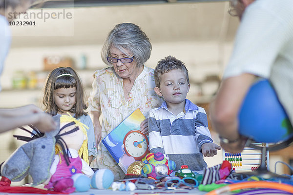 Kinder mit einem von Großmutter unterstützten Garagenverkauf