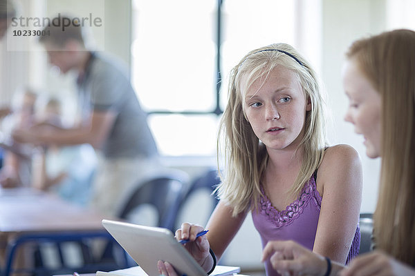 Zwei Schülerinnen im Klassenzimmer mit digitalem Tablettgespräch