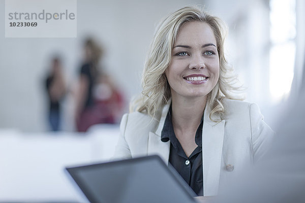 Porträt einer lächelnden blonden Frau von Angesicht zu Angesicht mit einem Geschäftspartner