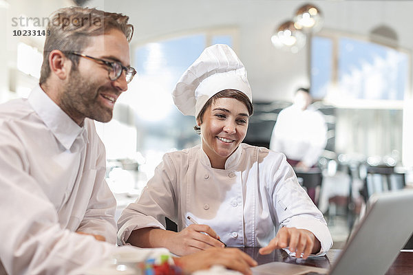 Restaurantchef und Manager diskutieren über das Menü