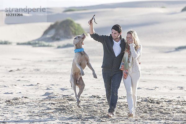Südafrika  Kapstadt  junges Paar am Strand mit Hund