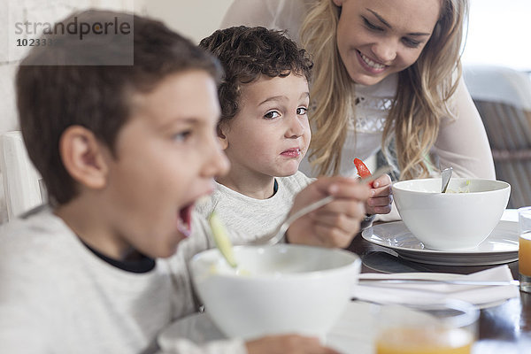 Junge mit Familie beim Mittagessen im Speisesaal  der sich weigert  gesund zu essen.