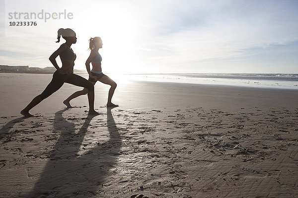 Südafrika  Kapstadt  zwei Frauen beim Stretching am Strand