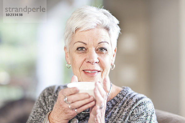Porträt einer weißhaarigen Seniorin mit Tasse
