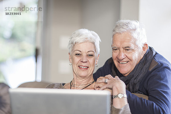 Seniorenpaar schaut zusammen auf den Laptop