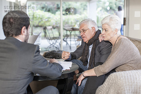 Seniorenpaar zu Hause bei einem Treffen mit dem Verkäufer